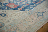 Distressed vintage Oushak carpet section: indigo field with palmettes, soft pile, pale rose-ivory border.