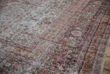 Distressed Khorassan rug texture, highlighting ivory, blush red floral motifs and visible foundation wear.