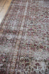 Faded cochineal red floral vinery on vintage distressed Khorassan rug's textured pile.