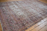 Distressed vintage Khorassan carpet showcasing worn texture, faded red vinery, and secure fringe.