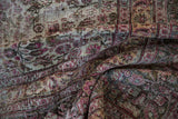 Distressed Khorassan rug's intricate vinery and worn texture in cochineal red, charcoal, ivory.