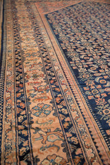 Detailed angle of the vintage Lilihan carpet's floral border against its navy blue Herati field.