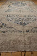 Distressed Khotan rug runner showing worn texture, faded navy patterns, and visible foundation.