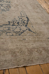 Visible foundation and worn dusty navy blue floral patterns on a distressed Khotan rug.