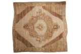 Distressed vintage Oushak rug with floral palmette medallion in ivory and coffee brown.
