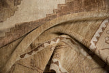 Distressed vintage Oushak rug close-up, showing short pile and stepped pattern in beige and brown.