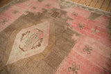 Distressed vintage Oushak rug pile with blush, coffee brown abrashes and a stepped medallion.