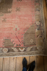 Distressed vintage Oushak rug with light antique ivory fringe and blush, brown geometric border.