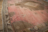 Distressed blush and coffee brown vintage Oushak rug with soft abrash.