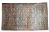 Distressed vintage Persian Mahal carpet, faded floral field, rust and blue Herati palmette border.