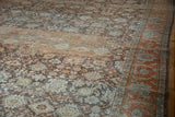 Distressed vintage Mahal rug detail showing a time-softened floral field and rust Herati border.