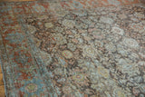 Textured distressed Persian Mahal rug with faded rust, dusty blue, and olive floral motifs.