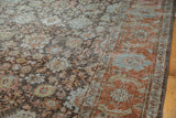 Vintage distressed Mahal carpet's worn pile, showcasing faded floral vinery and Herati border.