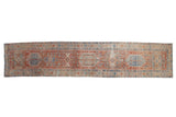 Distressed Karaja runner featuring geometric medallions in pale red, sky blue, and ivory. 3x14.5.