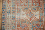Distressed Karaja runner pile showing geometric hook-and-latch designs in pale cherry and sky blue.