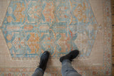 Distressed vintage Afshar rug texture with powder blue, dusty gold patterns, seen with boots.