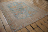 Distressed vintage Persian Afshar rug corner, highlighting worn pile, powder blue field, and intricate gold borders.