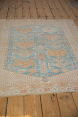 Distressed vintage Afshar rug texture showing worn powder blue and gold floral patterns.