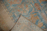 Distressed Afshar rug corner with powder blue floral cross sections, visible knot heads, and woven foundation.