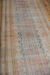 Angled view showing the mostly even wear and distressed boteh pattern of a vintage Mahal runner in rust and blue.