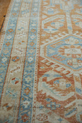 Distressed Heriz runner texture with geometric floral motifs in pale terra cotta and powder blue.