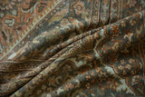 Distressed vintage Mahal carpet pile, featuring muted floral designs in slate, rose, and sand.