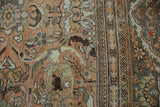 Distressed Mahal carpet, close-up of dusty rose floral motifs and meandering border design.