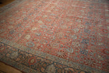 A perspective across the time-softened pile of a vintage Persian Bijar carpet's floral field.
