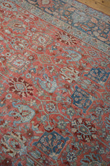 Low pile texture on a distressed Bijar carpet with classic ruby red and sky blue floral patterns.