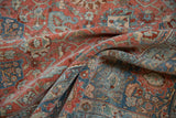 Soft folds of a distressed Bijar carpet reveal its low pile and detailed floral pattern.