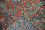 Folded corner of a distressed Bijar carpet revealing the low pile and intricate floral border design.