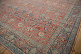 Corner of a distressed Bijar carpet with a soft ruby red floral field and wide sky blue border.