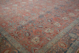Low angle view across a distressed Bijar carpet showing floral designs and a soft, worn texture.
