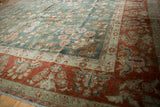 Distressed vintage Sarouk rug corner, rust border, deep green field, floral patterns.