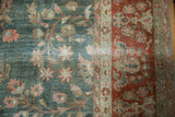 Detail of distressed vintage Persian Sarouk rug: playful green field florals meet rust border.