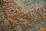 Distressed vintage Sarouk carpet border and muted green floral field, showing worn knot heads.