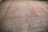 The intricate main border and softly worn floral pile of an antique distressed Kermanshah carpet.