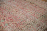 Angled view of the antique Kermanshah carpet's low pile revealing intricate floral arabesque details.
