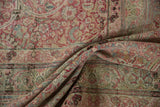 Soft folds on an antique Kermanshah carpet showing the low pile and intricate floral design.