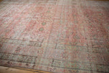 Low angle view across the intricate floral borders and time-softened texture of an antique Kermanshah rug.