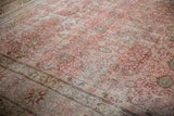 Inscribed weaver's signature cartouche on the main border of a distressed antique Persian carpet.