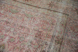 Mostly even wear on the intricate floral border and field of an antique Kermanshah carpet.