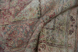 Time-softened texture and intricate floral pattern on a distressed antique Kermanshah rug pile.