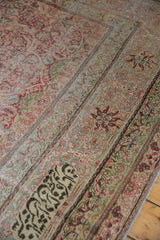 Inscribed weaver's signature cartouche inside the floral border of an antique Kermanshah carpet.