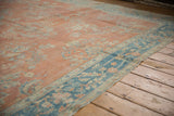 Distressed vintage Mahal carpet with wide dusty blue border, pale terra cotta field, and secured side.