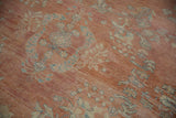Worn pile of vintage distressed Mahal carpet, showing pale terracotta and blue floral sprays.