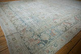 Distressed Doroksh rug border showing worn pile and expressive floral arabesque motifs.