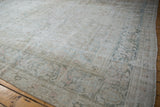Distressed ivory and pale teal Doroksh rug corner, highlighting worn texture and soft floral motifs.