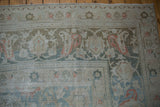 Distressed Doroksh carpet corner, faded floral arabesque border, ivory, pale teal, oxidized silver.