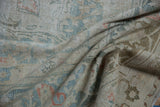 Distressed Doroksh carpet detail, worn pile revealing foundation, soft ivory and dusty teal.